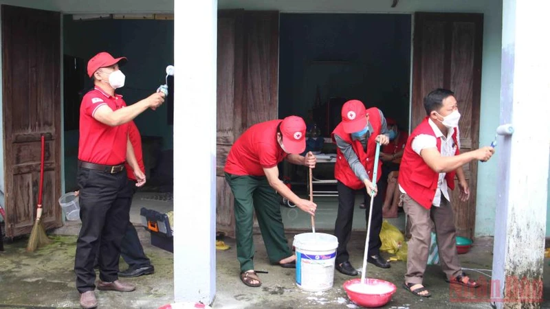 Các tình nguyện viên chữ thập đỏ sơn nhà cho các hộ gia đình khó khăn.