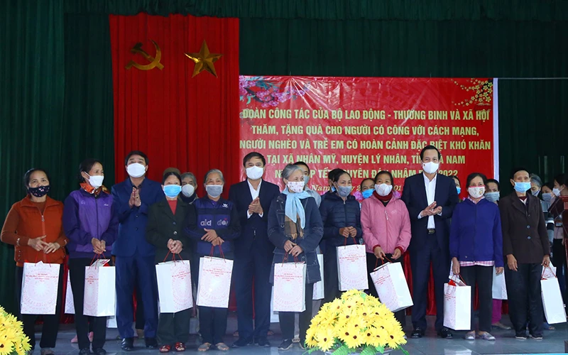 Bộ trưởng Đào Ngọc Dung, lãnh đạo tỉnh Hà Nam tặng quà gia đình chính sách, hộ nghèo tại chương trình. (Ảnh: Molisa)