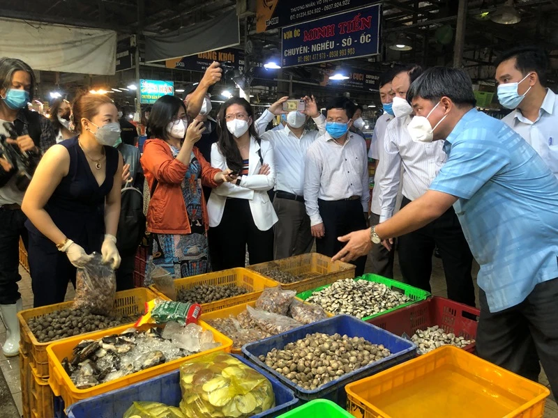 Thứ trưởng Nông nghiệp và Phát triển nông thôn Trần Thanh Nam (bên phải) trao đổi với tiểu thương chợ Bình Điền.
