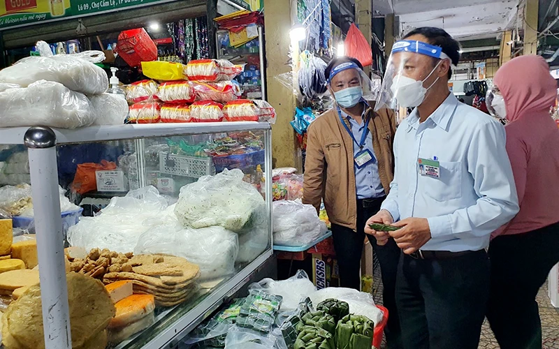Lực lượng liên ngành thành phố Ðà Nẵng kiểm tra, lấy mẫu test nhanh thực phẩm tại chợ Cẩm Lệ.