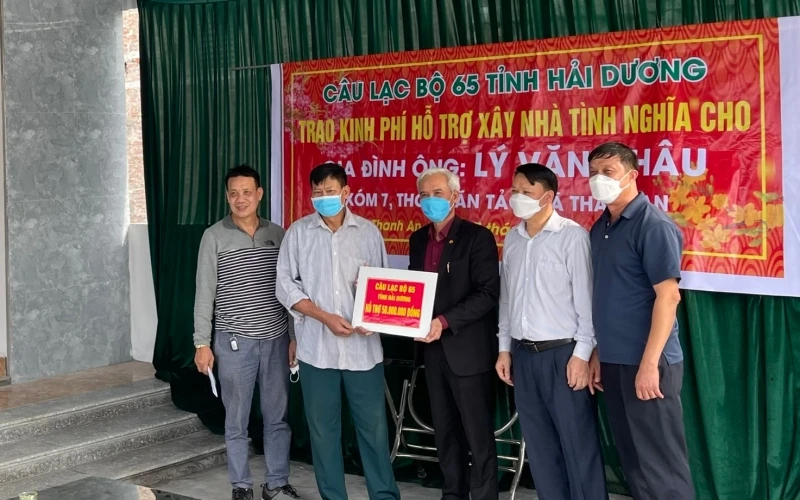 Đại diện câu lạc bộ 65 trao tặng kinh phí hỗ trợ xây nhà tình nghĩa cho anh Lý Văn Châu.