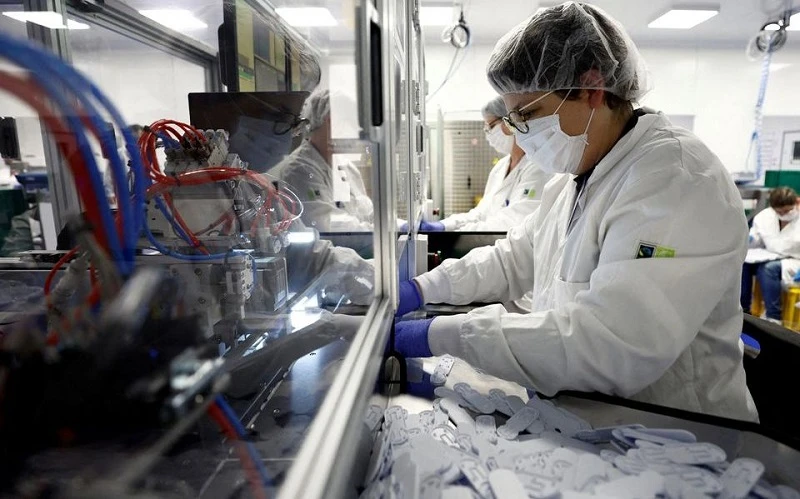 Nhân viên làm việc trên dây chuyền sản xuất bộ kit xét nghiệm Covid-19 tại nhà máy NG Biotech ở Guipry-Messac, Pháp, ngày 12/1/2022. (Ảnh: REUTERS)