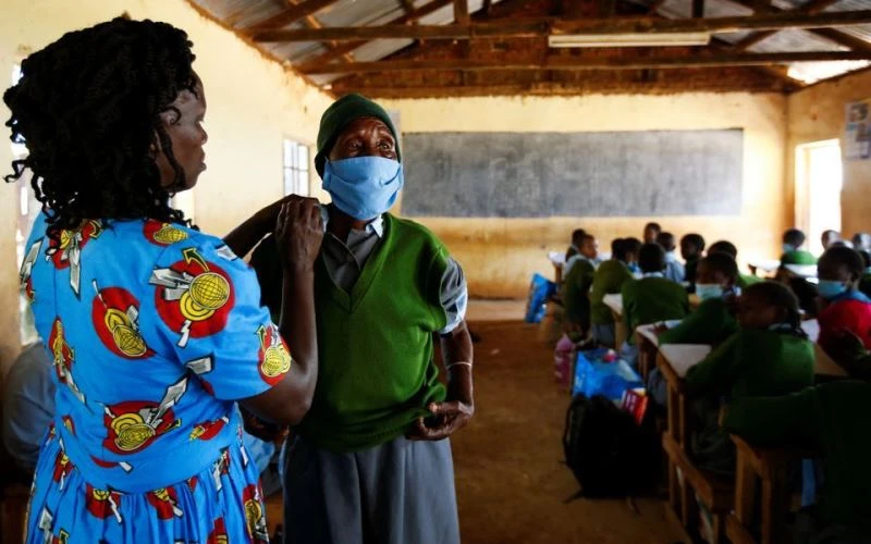 Cụ học sinh lớp 6 Priscilla Sitienei, 98 tuổi, được giáo viên chủ nhiệm Leonida Taalam giúp chỉnh lại đồng phục, Nandi, Kenya, ngày 25/1/2022. (Ảnh: REUTERS)