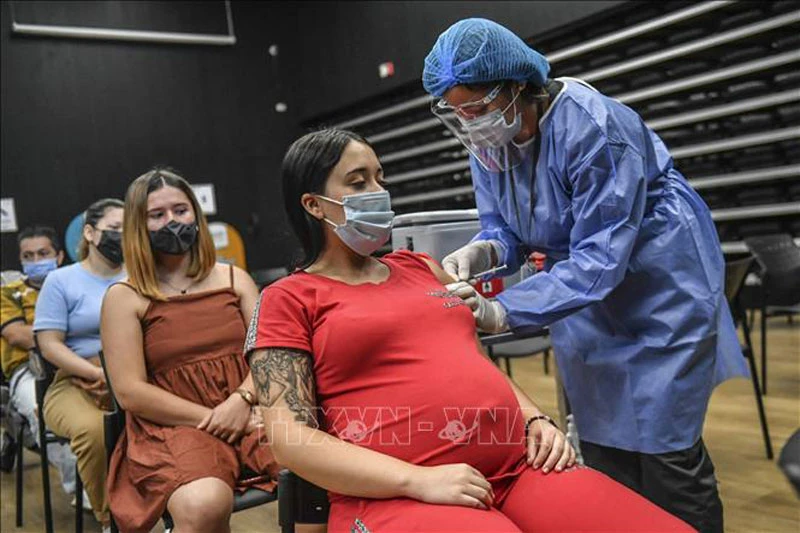 Nhân viên y tế tiêm vaccine ngừa Covid-19 của Pfizer-BioNTech cho phụ nữ mang thai tại Medellin, Colombia. (Ảnh: AFP/TXVN)