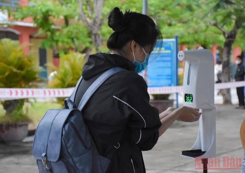 Học sinh khối 8 Trường THCS Phạm Ngọc Thạch (quận Sơn Trà, Đà Nẵng) đo thân nhiệt, rửa tay sát khuẩn trước khi vào lớp.