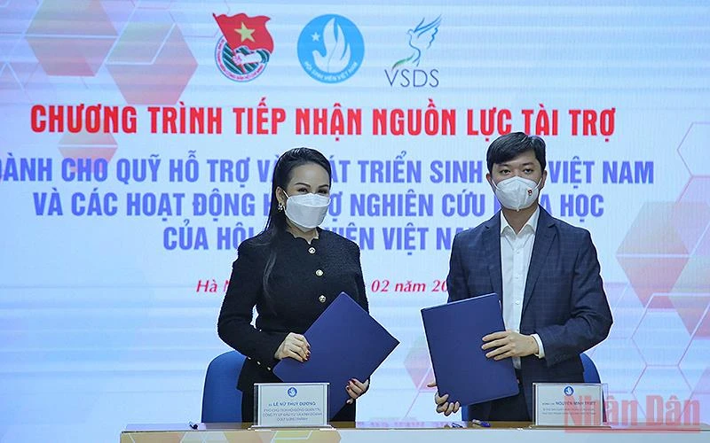 Bí thư Trung ương Đoàn, Chủ tịch Hội Sinh viên Việt Nam Nguyễn Minh Triết trao đổi biên bản cam kết tài trợ cho Quỹ Hỗ trợ và Phát triển sinh viên Việt Nam từ bà Lê Nữ Thùy Dương.