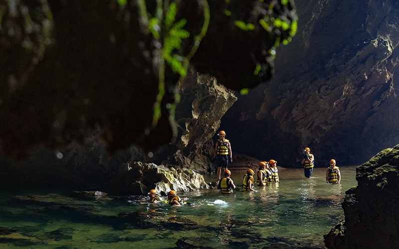 Du khách bơi qua sông ngầm khi khám phá hang Hổ, thuộc Vườn quốc gia Phong Nha-Kẻ Bàng. (Ảnh HẢI LÂM)