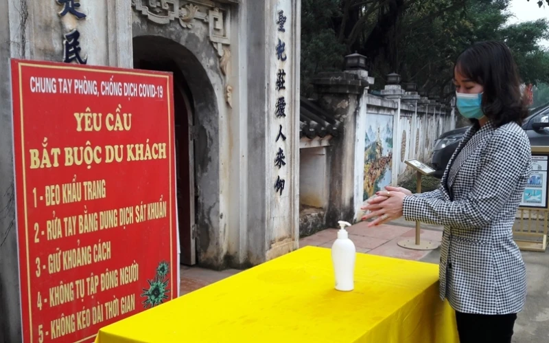Du khách đã tiêm đủ mũi vaccine, đeo khẩu trang, sử dụng dung dịch sát khuẩn trước khi vào tham quan di tích ở Thanh Hóa.