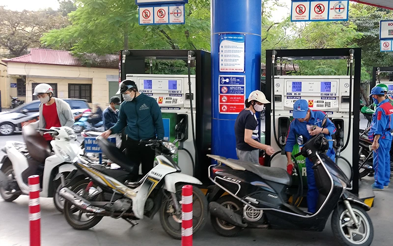 Người dân mua xăng tại cửa hàng xăng dầu trên phố Thái Thịnh (Đống Đa, Hà Nội).