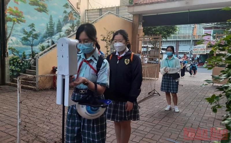 Học sinh Trường THCS Lý Phong, quận 5, TP Hồ Chí Minh kiểm tra thân nhiệt, sát khuẩn trước khi vào lớp học.
