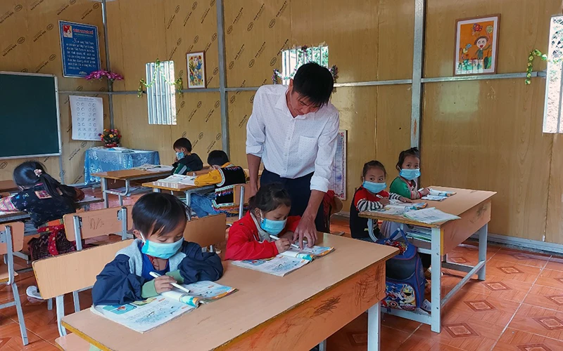 Thầy Lò Văn Chinh hướng dẫn học sinh lớp ghép 1 + 2 tại điểm bản Ma Lù Thàng làm bài tập. 