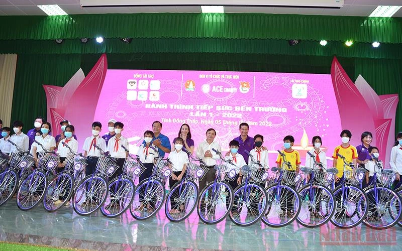 Các đồng chí Phan Văn Thắng, Huỳnh Minh Thức, cùng thành viên Câu lạc bộ ACE Charity trao tặng xe đạp cho học sinh. (Ảnh: HỮU NGHĨA)