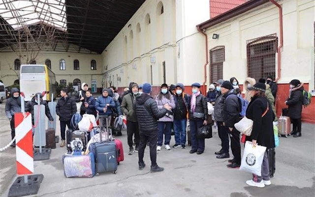 Người Việt sơ tán từ Ukraine tập trung tại điểm tập kết để đưa về cơ sở tị nạn chờ máy bay về Việt Nam. (Ảnh: Mạnh Hùng/TTXVN)
