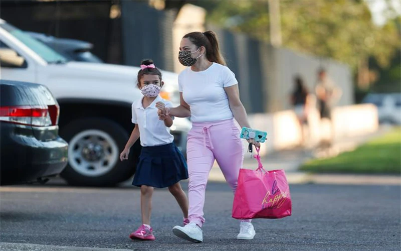 Mẹ đưa con gái đến Trường tiểu học West Tampa trong ngày đầu trường học mở cửa trở lại, Florida, ngày 10/8/2021. (Ảnh: Reuters)