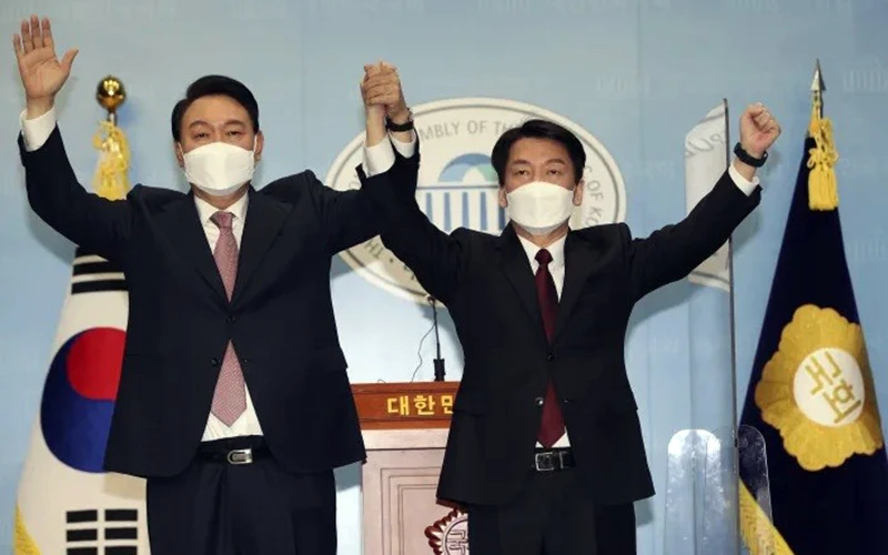 Hai ứng cử viên Yoon Suk-yeol (bên trái) và Ahn Cheol-soo tuyên bố hợp nhất tranh cử.