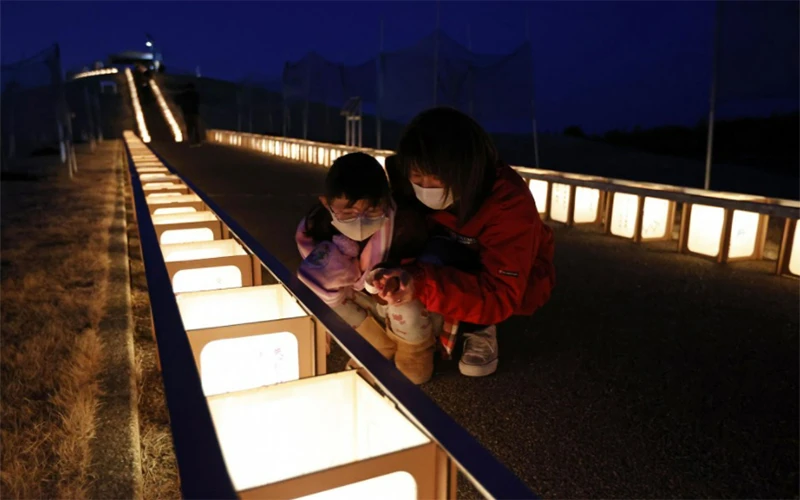 Người dân Nhật Bản thắp đèn tưởng nhớ nạn nhân của thảm họa động đất, sóng thần cách đây 11 năm. (Ảnh: Kyodo)