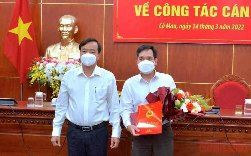 Chủ tịch Ủy ban nhân dân tỉnh Cà Mau (bìa trái) trao quyết định và tặng hoa chúc mừng tân Chánh Văn phòng Ủy ban nhân dân tỉnh.