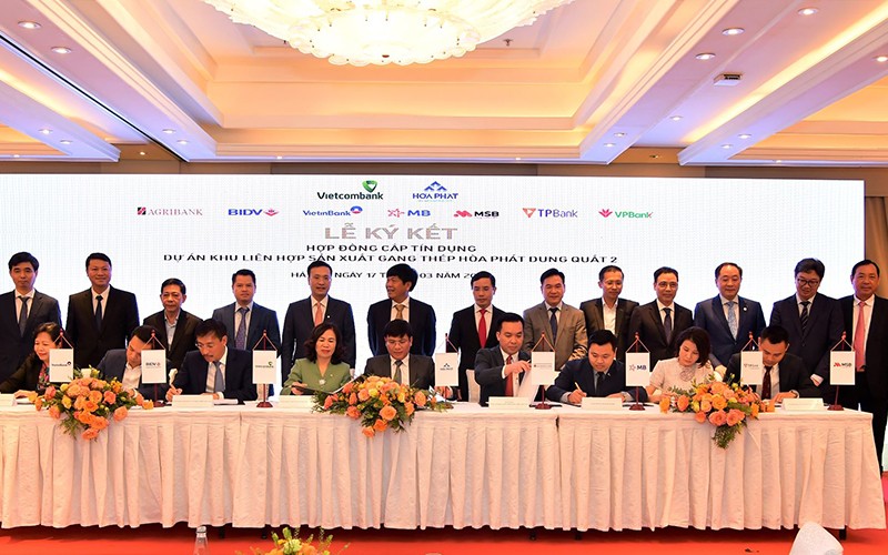 Ông Mai Văn Hà, Giám đốc Công ty cổ phần thép Hòa Phát Dung Quất (ngồi thứ 5 từ trái sang) và đại diện 8 ngân hàng do Vietcombank làm đầu mối đồng tài trợ ký kết Hợp đồng tín dụng.