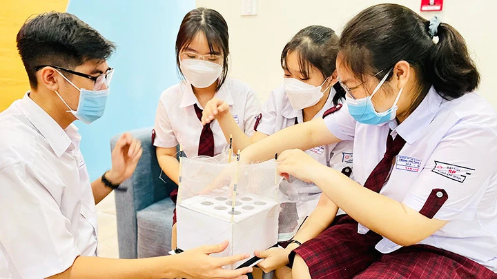 Các thành viên nhóm VBIN bên cạnh mô hình sản phẩm tiêu hủy thức ăn thừa bằng dòi ruồi lính đen.
