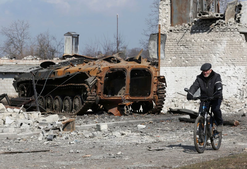 Người dân đạp xe qua một khu vực tại vùng Donetsk, Ukraine, ngày 15/3. (Ảnh: Reuters)