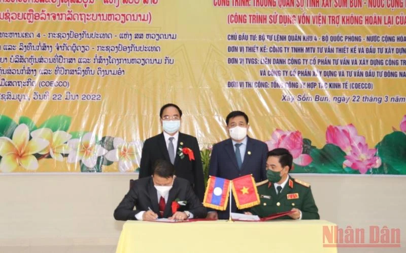 Tư lệnh Quân khu 4, Trung tướng Nguyễn Doãn Anh (trái) và Bí thư, Tỉnh trưởng tỉnh Xaysomboun Phoykham Hungbounnhuong ký biên bản bàn giao công trình. (Ảnh: Xuân Sơn)