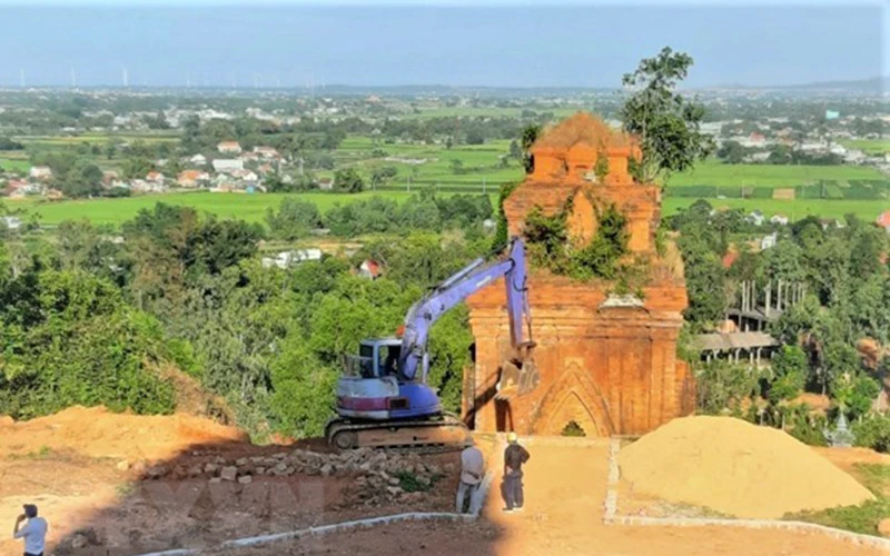 Nhà thầu thi công đưa máy đào vào thi công tại Di tích tháp Bánh Ít. (Ảnh: TTXVN)