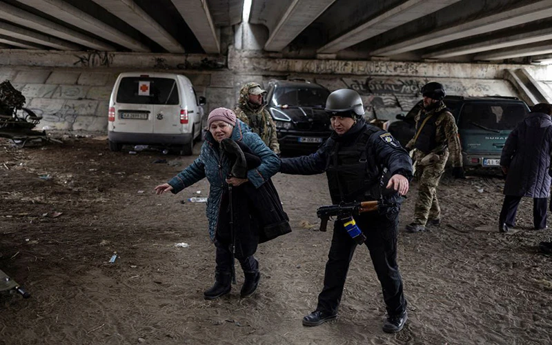 Quân nhân Ukraine hỗ trợ cụ bà tại khu vực Irpin, gần thủ đô Kiev, di dời đến nơi an toàn, ngày 13/3. (Ảnh: Reuters)