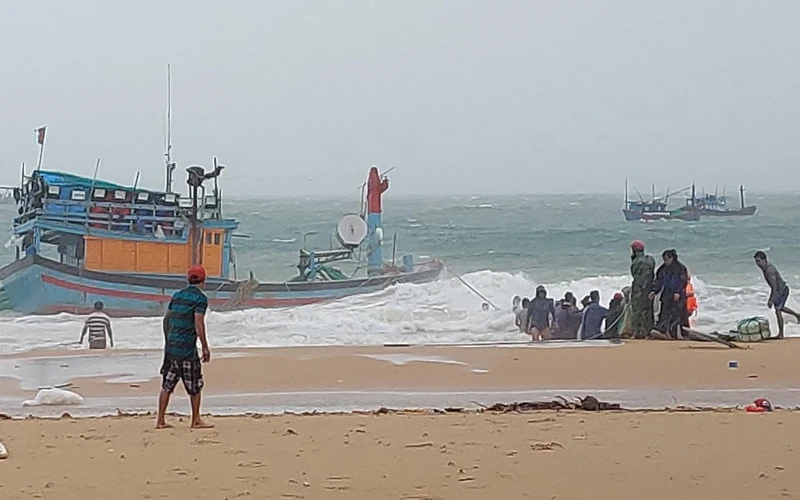Người dân cùng lực lượng cứu hộ nỗ lực cứu hộ tàu thuyền bị sóng lớn đánh chìm tại bãi biển Long Thuỷ, An Phú, thành phố Tuy Hòa.