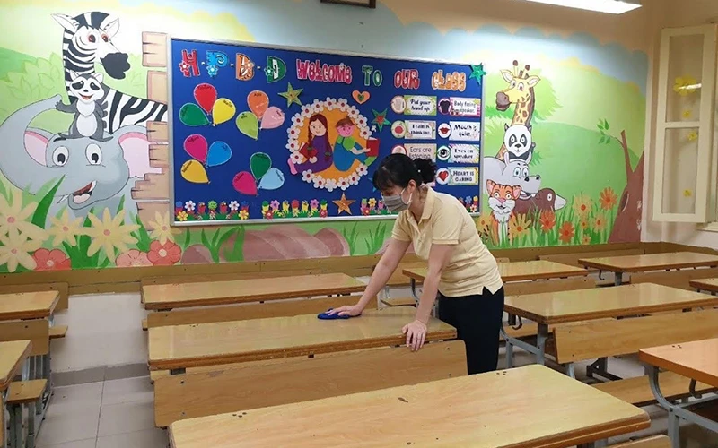 Giáo viên Trường Tiểu học Trần Quốc Toản (Hoàn Kiếm) vệ sinh lớp học chuẩn bị đón học sinh quay trở lại trường. (Ảnh: Đăng Anh)