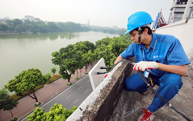 Nhân viên Công ty VNPT lắp đặt hệ thống hạ tầng viễn thông tại khu vực hồ Hoàn Kiếm, Hà Nội. (Ảnh VIẾT CHUNG)