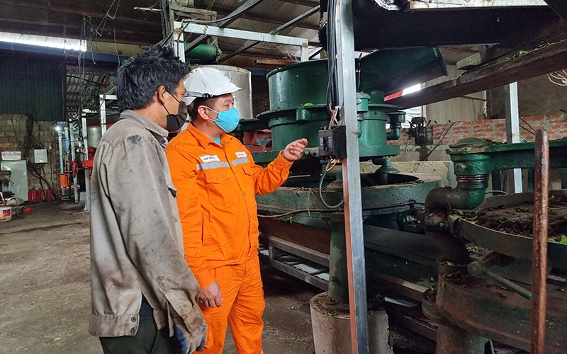 Cán bộ Điện lực Tân Uyên hướng dẫn công nhân cơ sở sản xuất chè Đức Hạnh sử dụng điện an toàn.