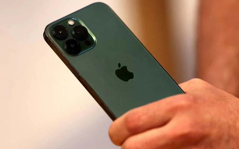 Một khách hàng cầm trên tay chiếc điện thoại iPhone 13 Pro màu xanh lục mới ngay sau khi nó được bày bán bên trong Apple Store tại Đại lộ số 5 ở Manhattan, New York City, tiểu bang New York, Mỹ, ngày 18/3/2022. (Ảnh: Reuters)