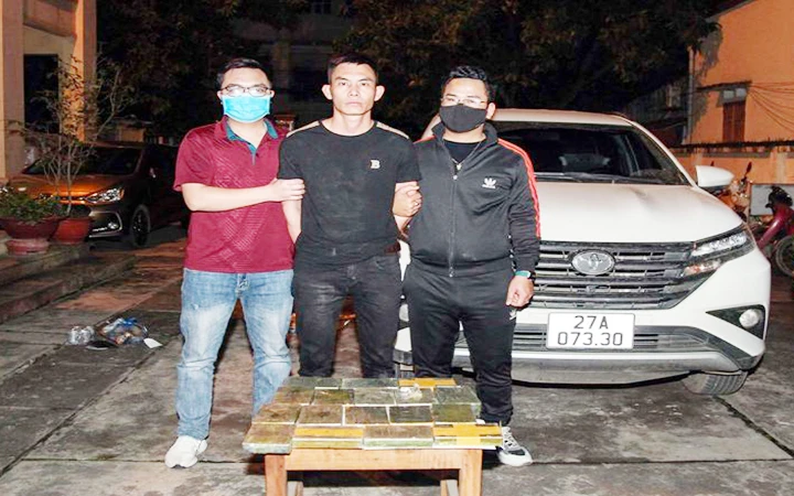Đối tượng Cà Văn Trí (giữa) cùng 17 bánh heroin bị bắt khi đang vận chuyển ma túy từ tỉnh Điện Biên về thành phố Thái Nguyên. (Ảnh Cơ quan công an cung cấp)