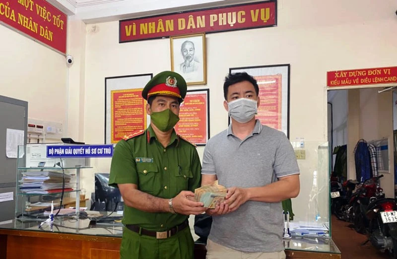Đại úy Nguyễn Đức Dũng trao trả 300 triệu đồng cho người đánh rơi.