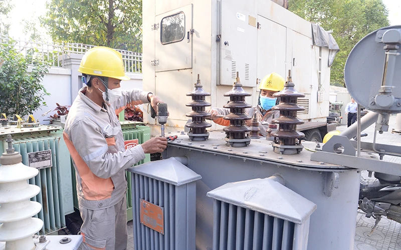 Công nhân Công ty Điện lực Thanh Hóa kiểm tra thiết bị trước khi lắp đặt để nâng công suất các máy biến áp ở thành phố Thanh Hóa.