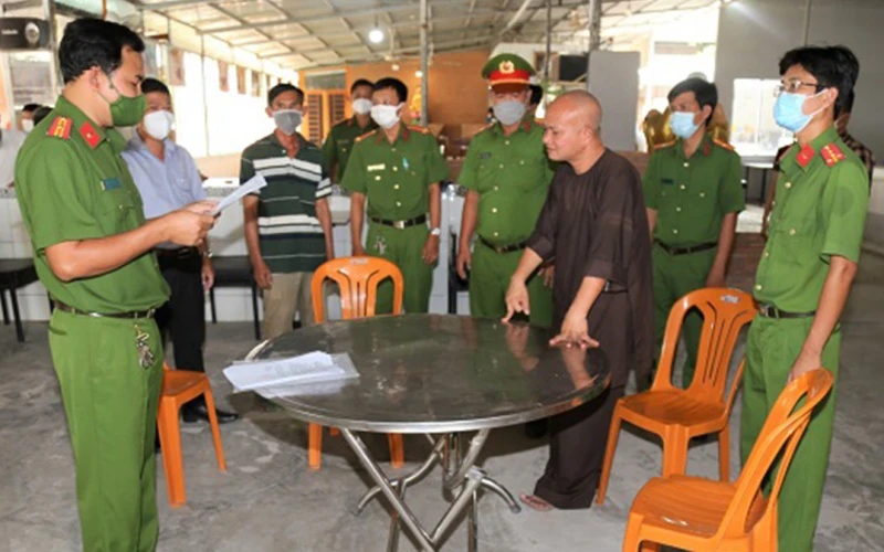 Cơ quan Cảnh sát điều tra thực hiện lệnh bắt tạm giam đối tượng Hồ Hữu Phúc (áo nâu). (Ảnh: Công an TP Sóc Trăng cung cấp)