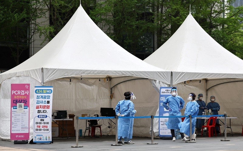 Các nhân viên y tế nghỉ ngơi tại điểm xét nghiệm Covid-19 ở Seoul, Hàn Quốc, ngày 24/4/2022. (Ảnh: Yonhap)