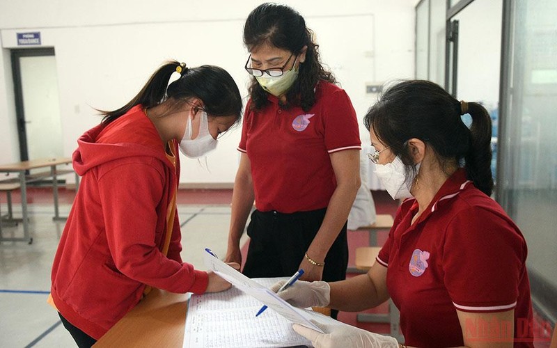Làm thủ tục chuẩn bị tiêm cho học sinh tại Hà Nội. (Ảnh: DUY LINH)