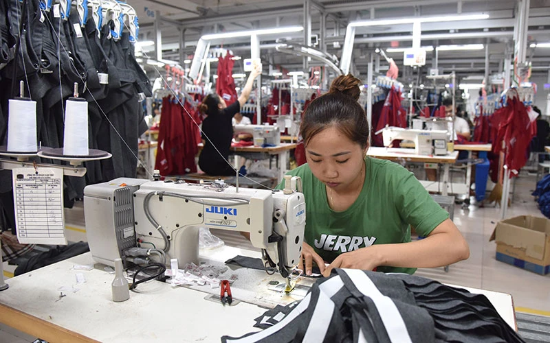 Công nhân Công ty cổ phần Nam Tiệp (Cụm công nghiệp An Xá, thành phố Nam Ðịnh) may quần áo xuất khẩu. (Ảnh NAM ANH) 