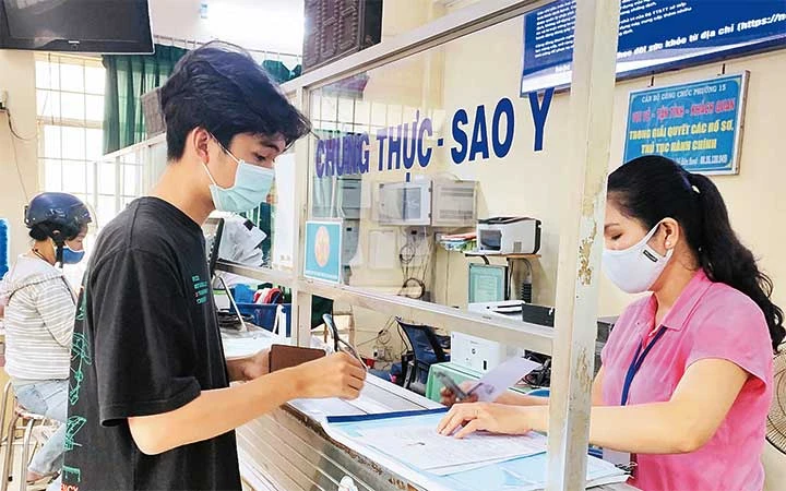 Người dân giao dịch thực hiện thủ tục hành chính tại trụ sở UBND phường 25, quận Bình Thạnh.
