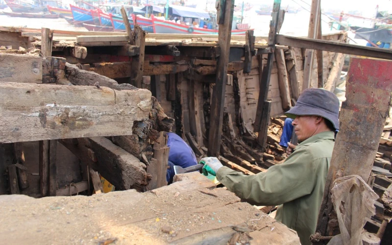Người lao động ở xã Ngư Lộc, huyện Hậu Lộc tháo dỡ cấu kiện con tàu giải bản.