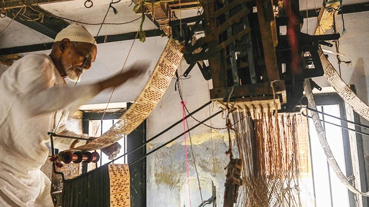 Một thợ dệt sari thủ công ở Varanasi. Ảnh: AFP