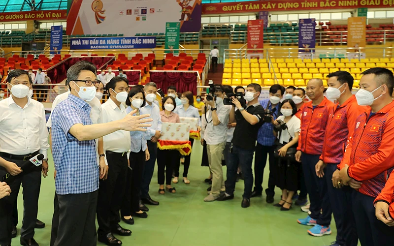 Phó Thủ tướng Vũ Ðức Ðam trò chuyện với các vận động viên đang tập luyện tại Nhà thi đấu Bắc Ninh. (Ảnh NAM NGUYỄN)