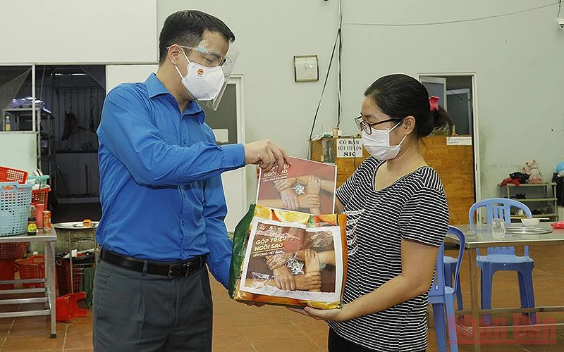 Đồng chí Ngô Văn Cương, Bí thư Trung ương Đoàn (bên trái trong ảnh) trao kinh phí hỗ trợ của chương trình “Góp triệu ngôi sao”, khích lệ tiểu thương tại thành phố Hồ Chí Minh vượt đại dịch.
