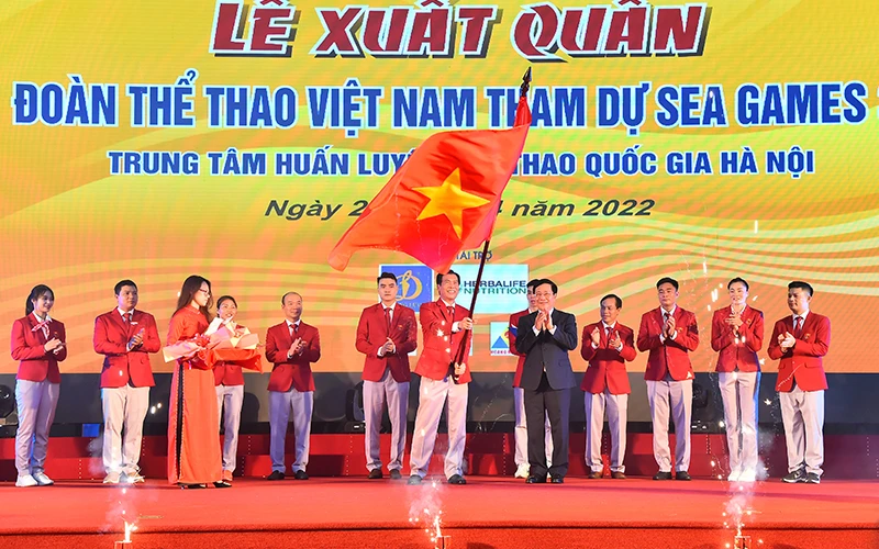 Trưởng đoàn Thể thao Việt Nam Trần Đức Phấn nhận cờ từ Phó Thủ tướng Thường trực Chính phủ Phạm Bình Minh, cũng là nhận vinh dự và trách nhiệm với Tổ quốc. Ảnh: MỸ HÀ