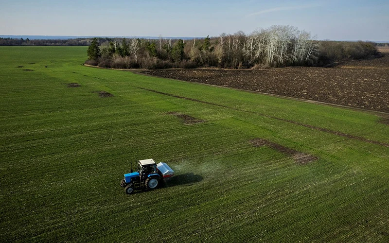 Máy kéo rải phân bón trên cánh đồng lúa mì gần làng Yakovlivka, gần TP Kharkiv, ngày 5/4/2022. (Ảnh: Reuters)