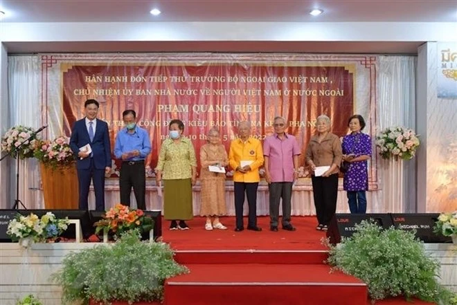 Thứ trưởng Phạm Quang Hiệu (ngoài cùng, trái sang) tặng quà cho các hội đoàn người Việt cùng một số kiều bào có công, kiều bào lão thành. (Ảnh: Hữu Kiên/TTXVN)