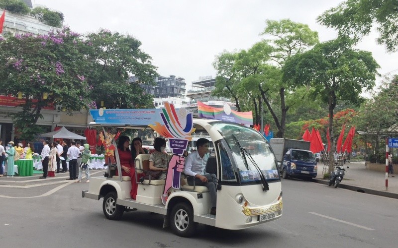 Du khách trên hành trình khám phá phố phường Hà Nội bằng xe điện.
