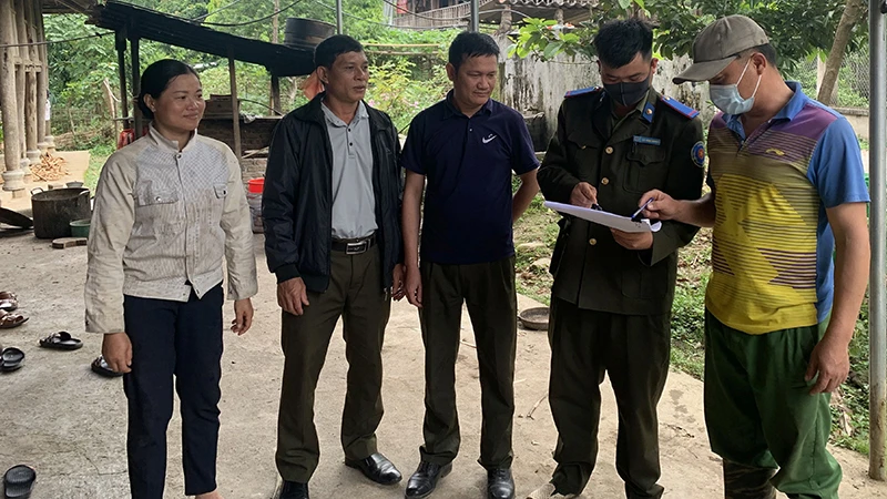 Trưởng bản Lò Văn Thân (đầu tiên, bên phải) thông báo kế hoạch tuần tra, bảo vệ rừng đến các thành viên trong bản Pom Cại.