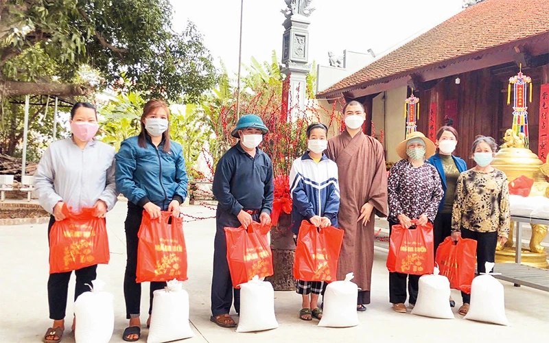 Nhóm Hoa Đăng cùng đại diện chùa Sùng Quang tặng quà cho những người có hoàn cảnh khó khăn.